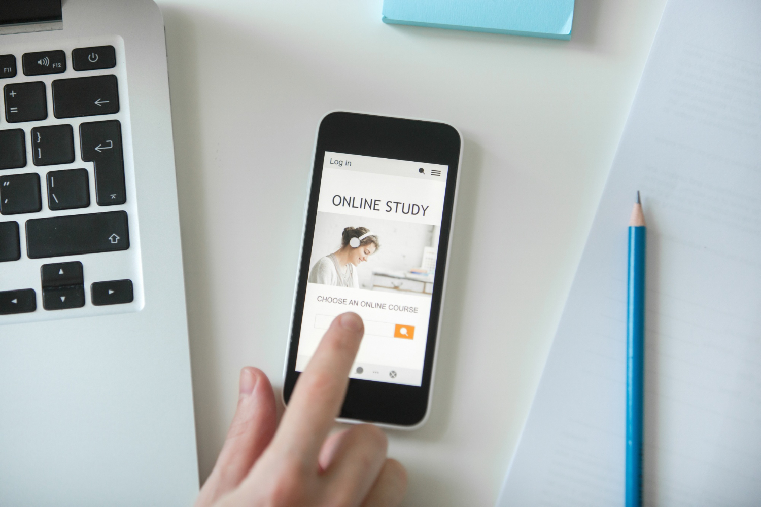 A finger tapping a search on a phone beside a laptop, representing multiple touchpoints in a customer journey